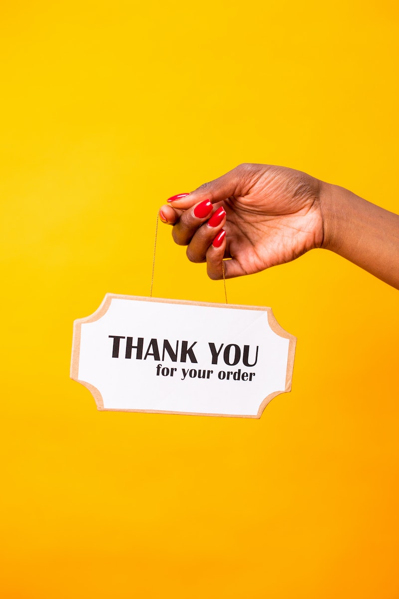 A Person Holding a Thank You Hanging Signage